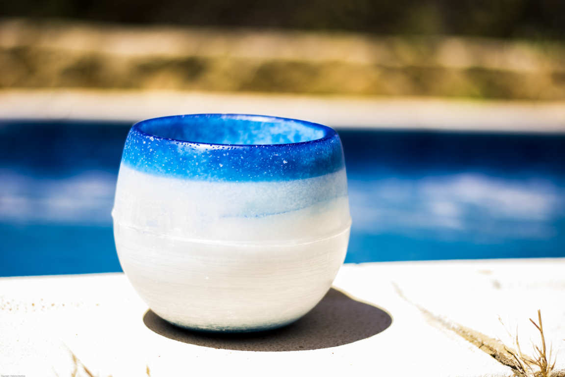 Cuenco de parafina color azul sobre bordillo de piscina